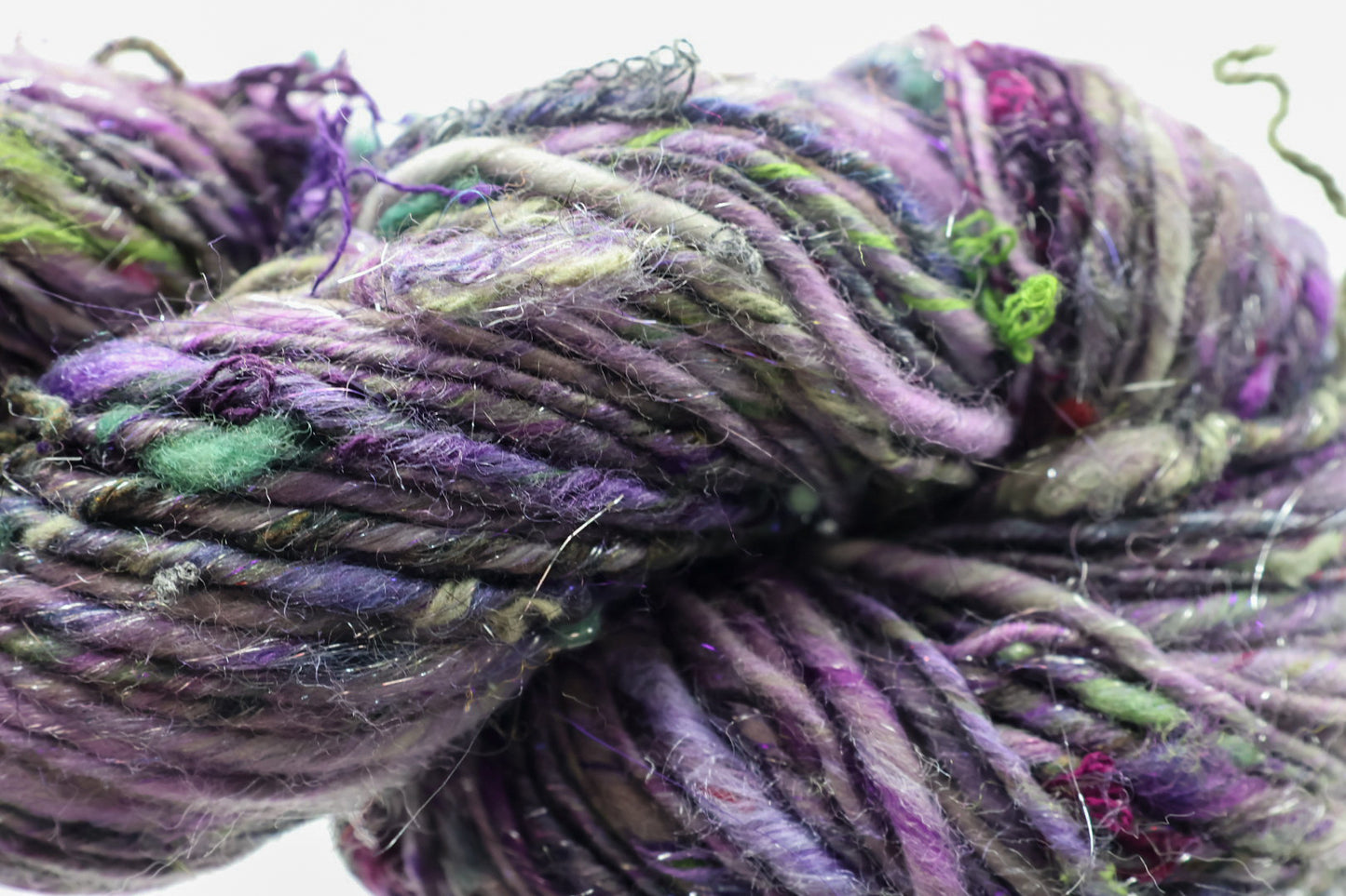 Close-up of multicolored yarn with purple, green, and gray hues.