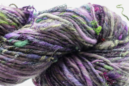 Close-up of multicolored yarn with purple, green, and gray hues.