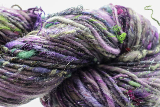 Close-up of multicolored yarn with purple, green, and gray hues.